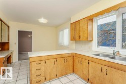 Kitchen with a peninsula, tile countertops, light tile patterned flooring, and tasteful backsplash - 