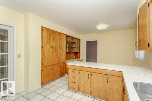 Kitchen with tile counters, a peninsula, and light tile patterned floors - 6304 131 Street, Edmonton, AB - Indoor Photo Showing Kitchen
