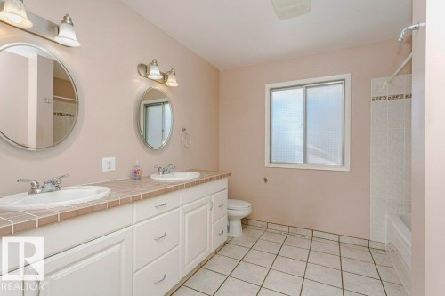 Full bathroom with double vanity, light tile patterned floors, and bathing tub / shower combination - 6304 131 Street, Edmonton, AB - Indoor Photo Showing Bathroom