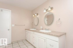 Full bathroom featuring double vanity and light tile patterned floors - 