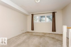 Carpeted empty room with a textured ceiling and baseboards - 
