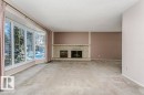 Unfurnished living room featuring a fireplace, carpet flooring, and a textured ceiling - 6304 131 Street, Edmonton, AB  - Indoor Photo Showing Living Room With Fireplace 