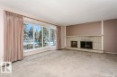 Unfurnished living room with a brick fireplace, a textured ceiling, and carpet floors - 6304 131 Street, Edmonton, AB  - Indoor Photo Showing Living Room With Fireplace 