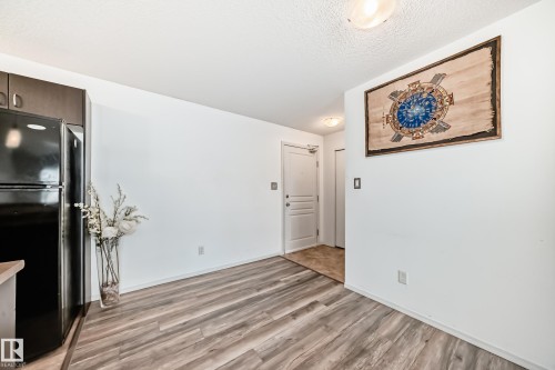 Unfurnished dining area featuring light wood-type flooring and a textured ceiling - 306 1188 Hyndman Road, Edmonton, AB - Indoor Photo Showing Other Room