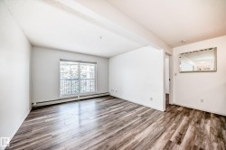 Unfurnished room featuring a baseboard heating unit and light wood-style flooring - 