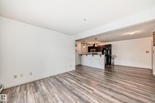 Unfurnished living room with wood finished floors and baseboards - 306 1188 Hyndman Road, Edmonton, AB - Indoor