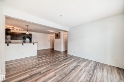 Unfurnished living room featuring light wood-type flooring and baseboards - 