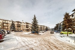 Snow covered building featuring a view of apartment building / complex - 