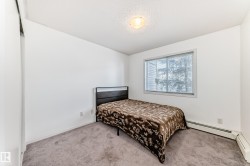 Carpeted bedroom featuring baseboard heating and a textured ceiling - 