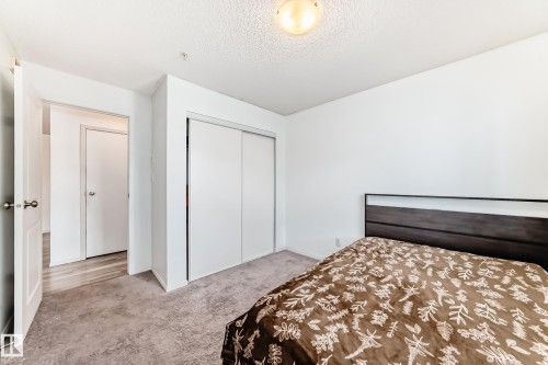 Carpeted bedroom featuring a closet and a textured ceiling - 306 1188 Hyndman Road, Edmonton, AB - Indoor Photo Showing Bedroom