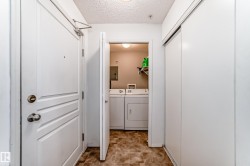 Laundry area featuring a textured ceiling, washer and clothes dryer, and electric panel - 