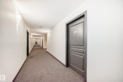 Corridor featuring light carpet and baseboards - 