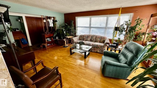Living room featuring light wood-style flooring and a textured ceiling - 52012 Hwy 21, Rural Strathcona County, AB - Indoor Photo Showing Living Room