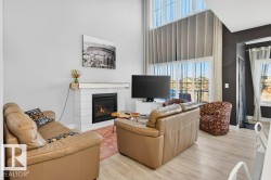 Open concept great room with gas fireplace, exceptional natural light, vast views of the pond, and 18' ceilings. - 