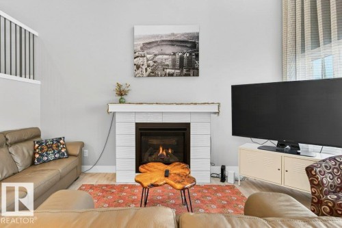 Open-to-below great room flanked by huge windows looking out over the deck and to the pond + the vast open staircase leading to the second floor. - 1909 Davidson Wynd, Edmonton, AB - Indoor Photo Showing Living Room With Fireplace