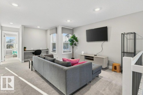 Bonus room with light carpet, plenty of natural light, a textured ceiling, recessed lighting, and built in desk. - 1909 Davidson Wynd, Edmonton, AB - Indoor