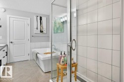 Primary bedroom ensuite with free standing tub and glass-enclosed shower. - 