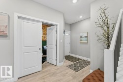 Foyer entrance with light wood-style flooring, stairs, recessed lighting, and a textured ceiling - 