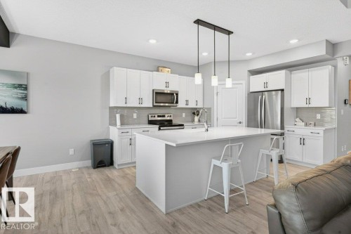 Spacious kitchen with large island, corner walkthrough pantry and beautifully modern, neutral-toned finishing details. - 1909 Davidson Wynd, Edmonton, AB - Indoor Photo Showing Kitchen With Upgraded Kitchen