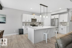 Spacious kitchen with large island, corner walkthrough pantry and beautifully modern, neutral-toned finishing details. - 