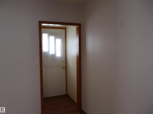 Hallway with dark wood-style floors - 5109 55 Street, Barrhead, AB - Indoor Photo Showing Other Room