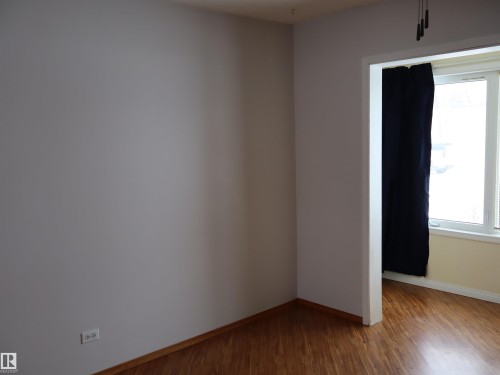Unfurnished room with wood finished floors and baseboards - 5109 55 Street, Barrhead, AB - Indoor Photo Showing Other Room