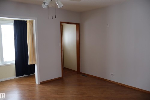 Unfurnished room featuring dark wood-style floors and ceiling fan - 5109 55 Street, Barrhead, AB - Indoor Photo Showing Other Room