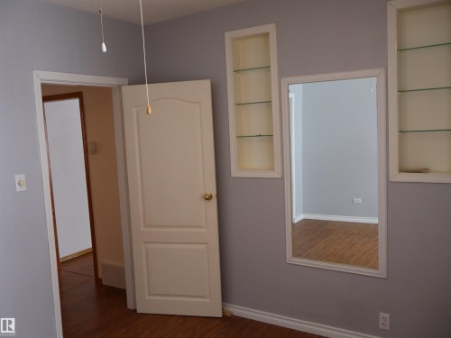 Unfurnished bedroom with baseboards and dark wood-style floors - 5109 55 Street, Barrhead, AB - Indoor Photo Showing Other Room