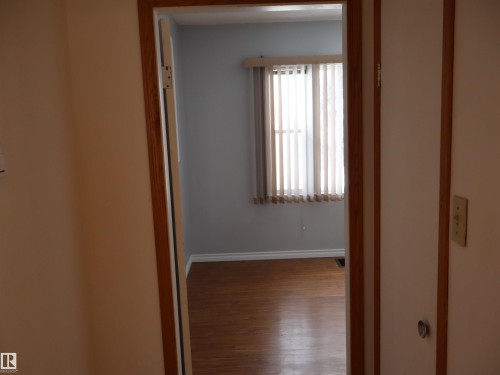 Hallway with dark wood-style floors and baseboards - 5109 55 Street, Barrhead, AB - Indoor Photo Showing Other Room