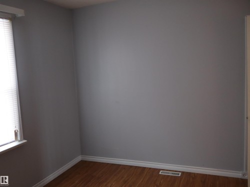 Spare room featuring baseboards and dark wood-type flooring - 5109 55 Street, Barrhead, AB - Indoor Photo Showing Other Room