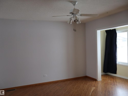 Spare room featuring wood finished floors, a textured ceiling, and ceiling fan - 5109 55 Street, Barrhead, AB - Indoor Photo Showing Other Room