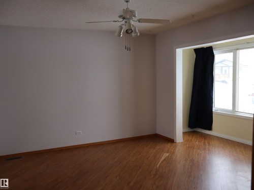 Unfurnished room with wood finished floors, ceiling fan, and a textured ceiling - 5109 55 Street, Barrhead, AB - Indoor Photo Showing Other Room