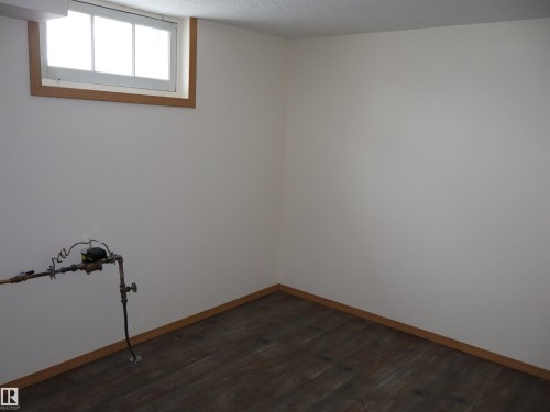 Unfurnished room with dark wood-style floors and a textured ceiling - 5109 55 Street, Barrhead, AB - Indoor Photo Showing Other Room