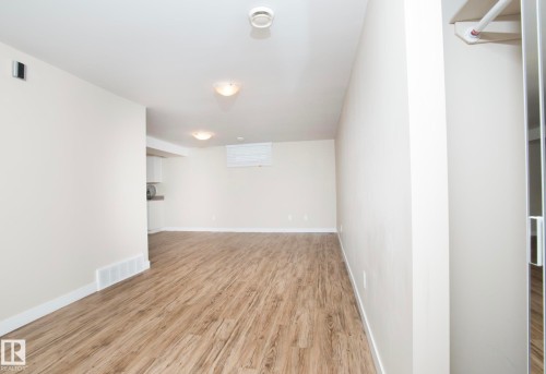 Unfurnished room featuring light wood-style flooring and baseboards - 13616 82 Street Nw, Edmonton, AB - Indoor Photo Showing Other Room