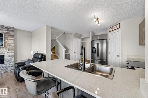 9040 Cooper Link, Edmonton, AB - Indoor Photo Showing Kitchen With Fireplace With Double Sink