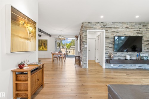 Living area with light wood-type flooring and suspended lighting - 14412 80 Avenue Nw, Edmonton, AB - Indoor Photo Showing Living Room