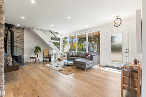 Living room with light wood-type flooring, a wood stove, and recessed lighting - 14412 80 Avenue Nw, Edmonton, AB - Indoor