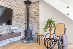 Living area featuring a wood stove and wood finished floors - 