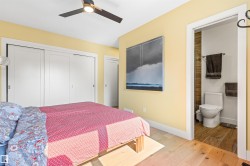 Bedroom featuring hardwood / wood-style flooring, a closet, ceiling fan, and ensuite bath - 