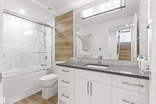 Full bath with vanity, bath / shower combo with glass door, and light wood-style floors - 14412 80 Avenue Nw, Edmonton, AB - Indoor Photo Showing Bathroom