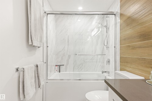 Full bath featuring combined bath / shower with glass door, vanity, and wooden walls - 14412 80 Avenue Nw, Edmonton, AB - Indoor Photo Showing Bathroom