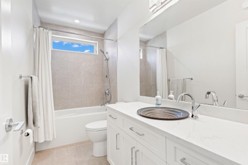 Bathroom with vanity, shower / bath combo with shower curtain, and light tile patterned flooring - 14412 80 Avenue Nw, Edmonton, AB - Indoor Photo Showing Bathroom