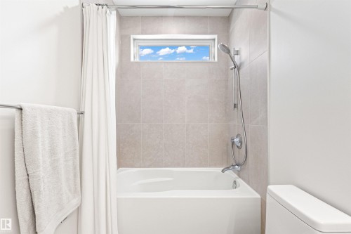 Bathroom featuring toilet and shower / bathtub combination with curtain - 14412 80 Avenue Nw, Edmonton, AB - Indoor Photo Showing Bathroom