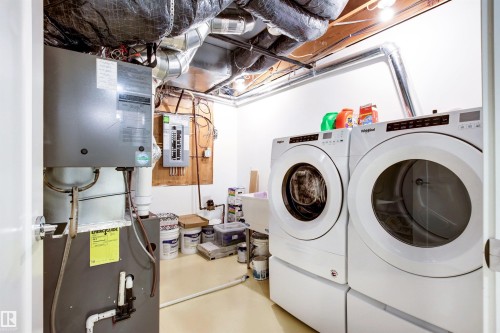 Laundry area with electric panel, washer and dryer, and heating unit - 14412 80 Avenue Nw, Edmonton, AB - Indoor Photo Showing Laundry Room