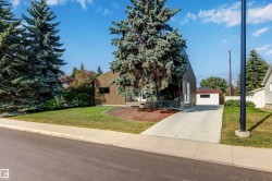 Obstructed view of property featuring a front yard, a detached garage, and an outbuilding - 