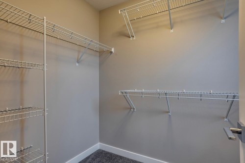 Walk in closet featuring dark colored carpet - 78 13139 205 Street Nw, Edmonton, AB - Indoor With Storage