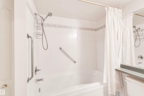 Bathroom featuring shower / tub combo with curtain and toilet - 209 17150 94A Avenue, Edmonton, AB - Indoor Photo Showing Bathroom