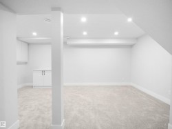 Finished basement with light colored carpet and recessed lighting - 