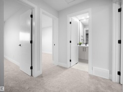 Hall featuring light carpet and baseboards - 