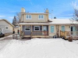 Snow covered back of property featuring a chimney, a porch, and an outdoor structure - 